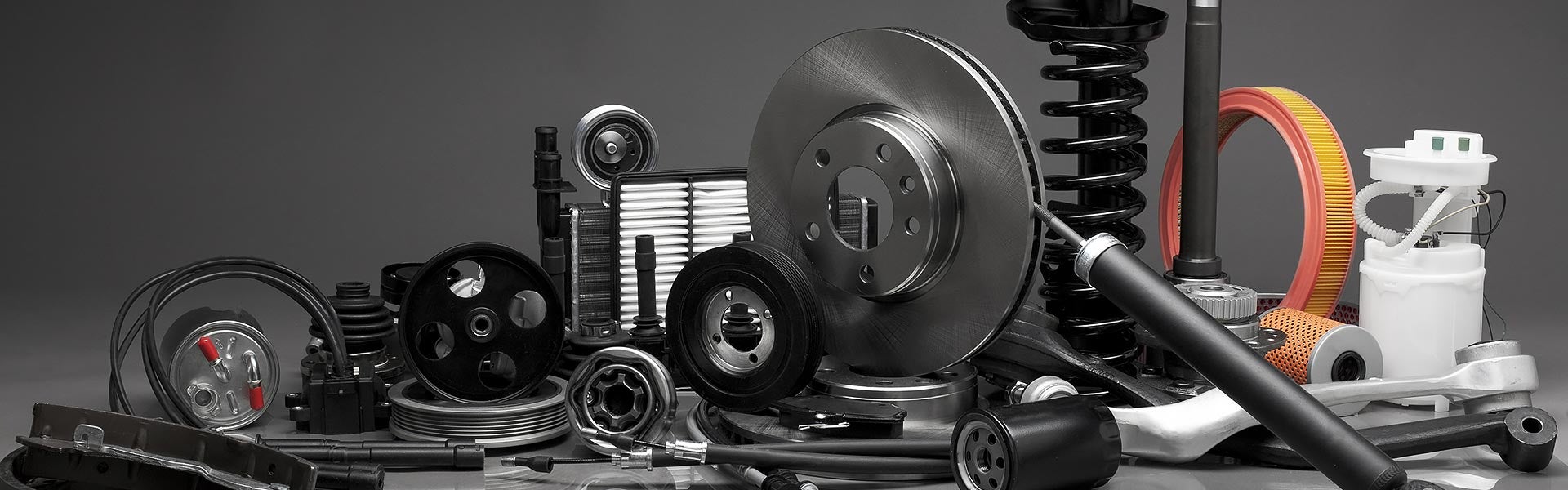 Collection of various automotive spare parts displayed against a grey background